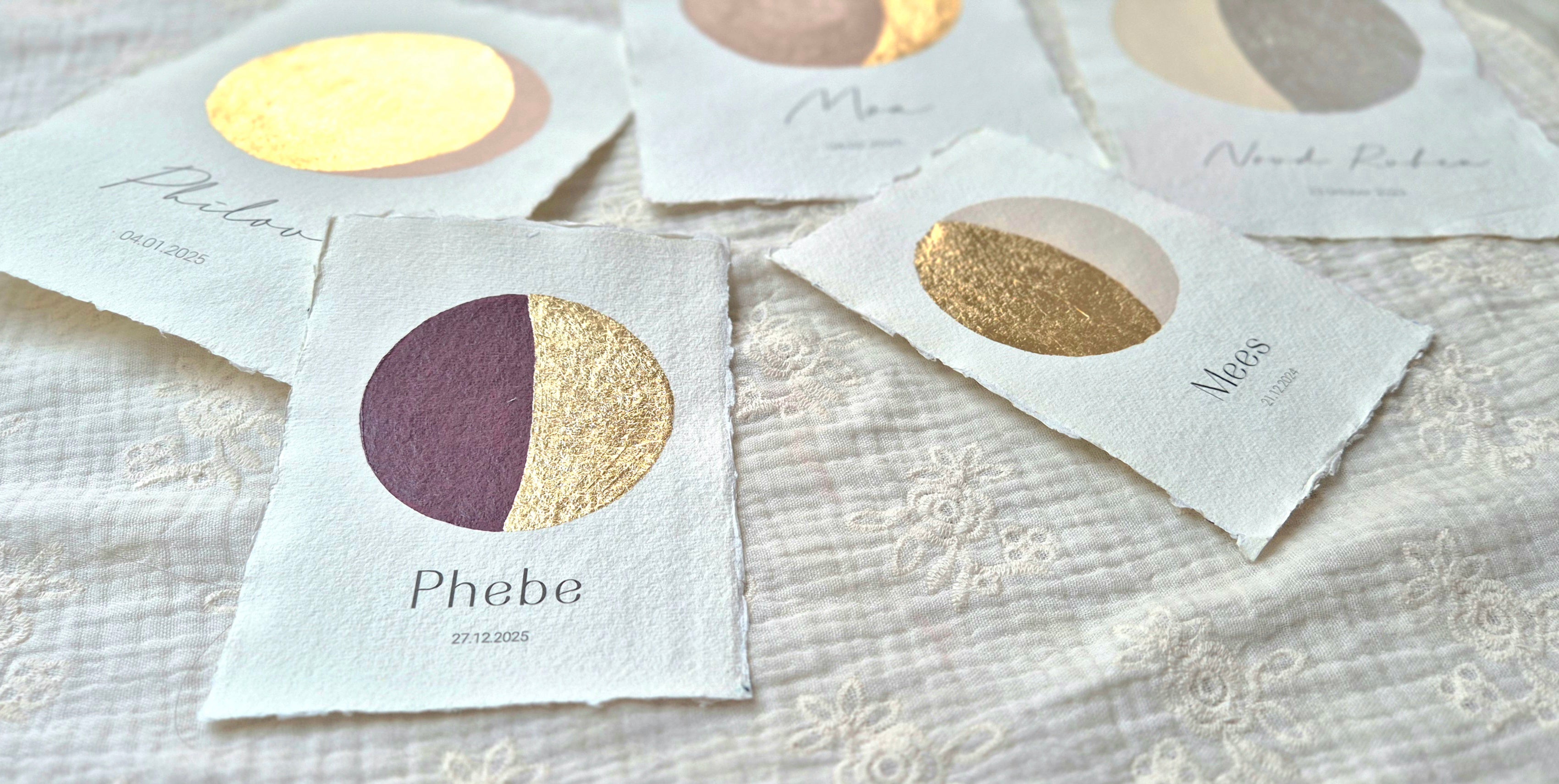 Handgemaakte maanstand posters op geschept papier, met goudfolie details en gepersonaliseerde namen en data. Zachte, natuurlijke tinten zorgen voor een tijdloze en verfijnde uitstraling.