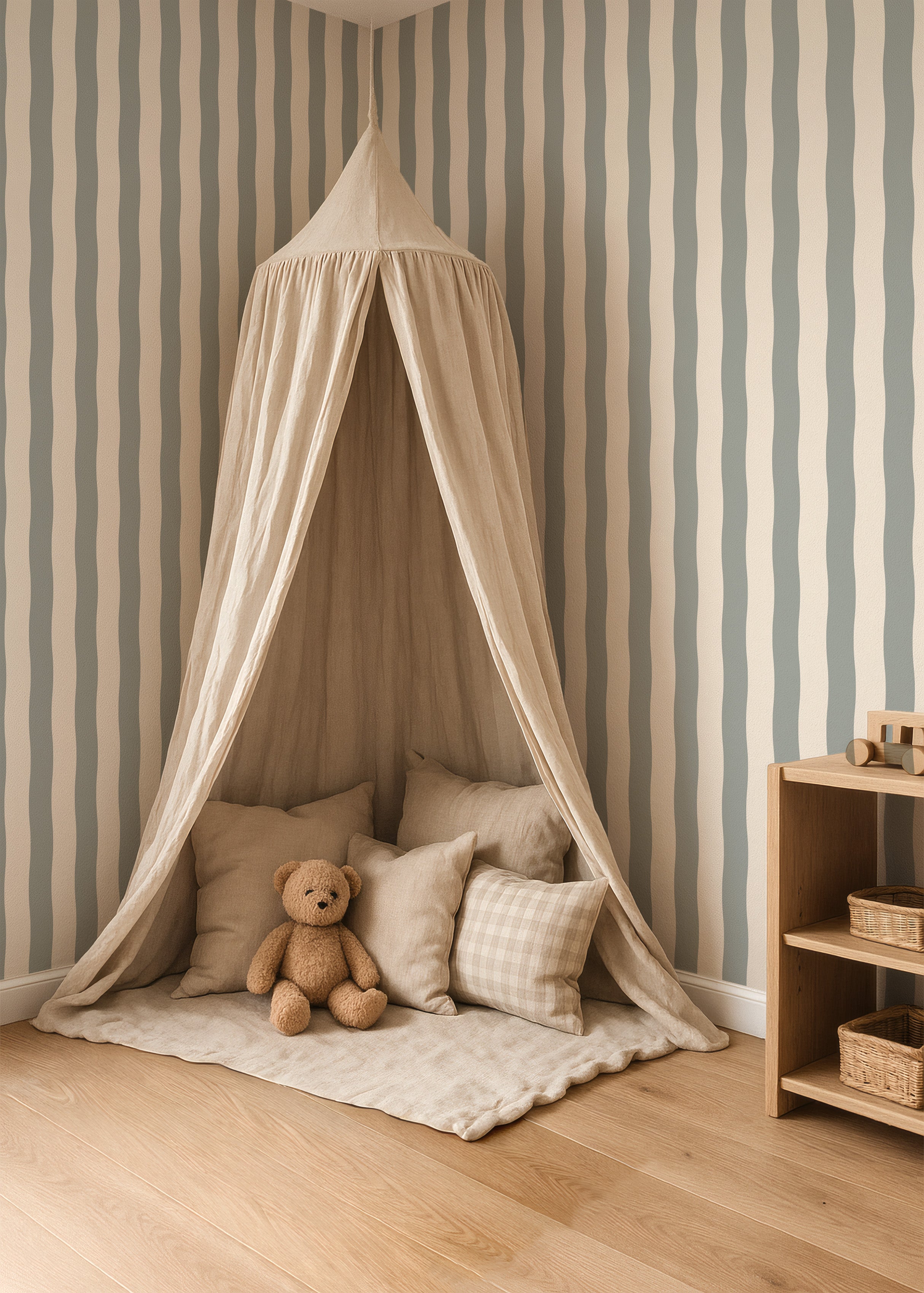 Rustige kinderkamer met Wavy Stripes vintage green behang, speelhoek met zachte stoffen hemel, kussens en knuffel in natuurlijke tinten.