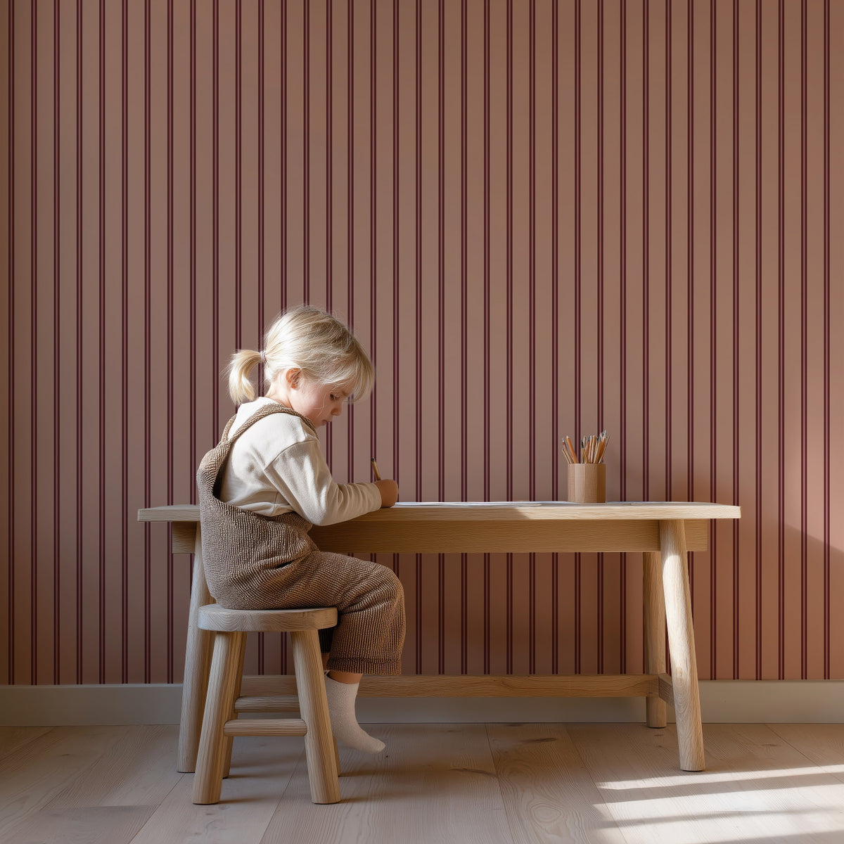 Twin Stripes - blush rouge behang als achtergrond bij een kind aan een houten bureau