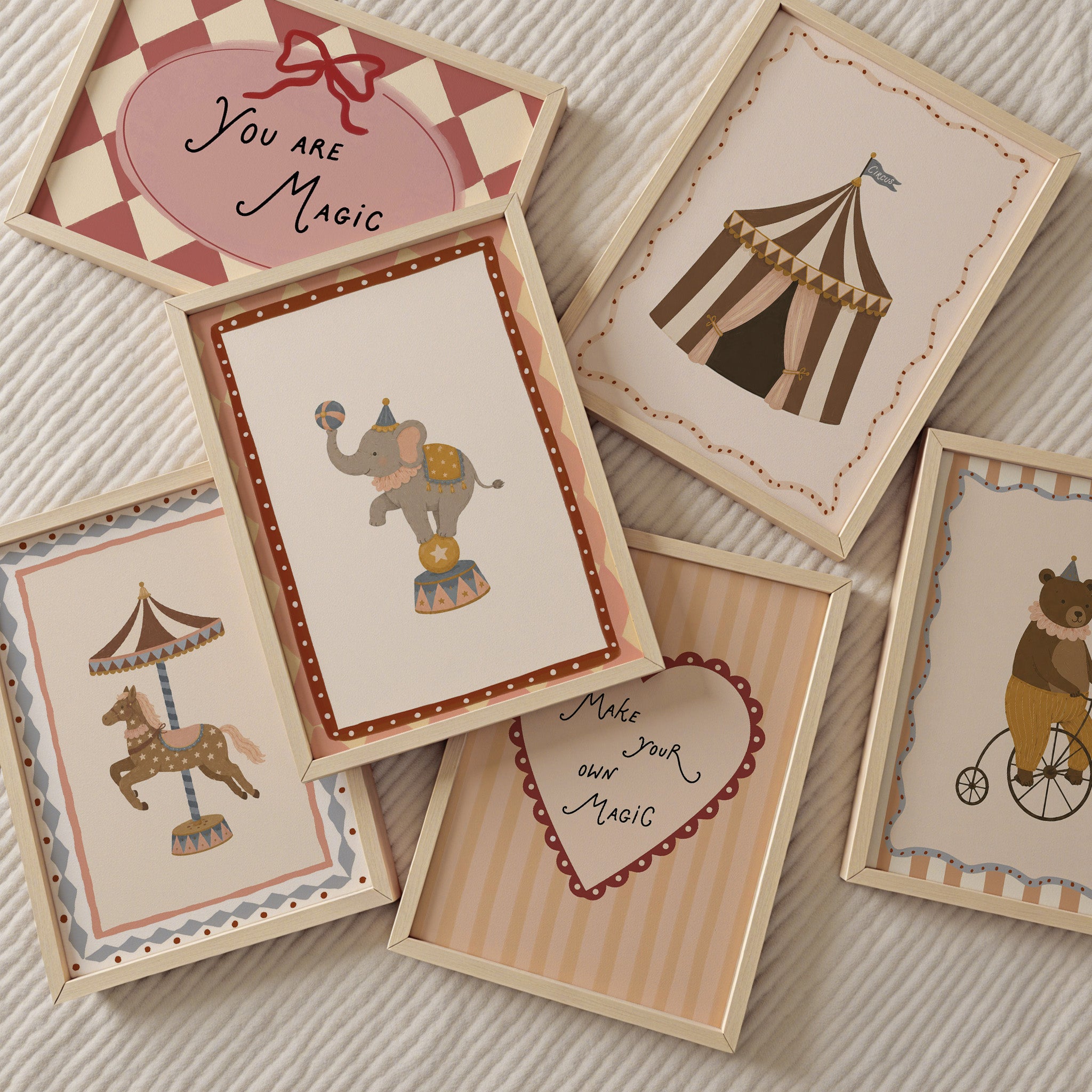 Sfeerbeeld van een retro circus poster set voor de kinderkamer met ingelijste illustraties van een circusolifant, circustent, draaimolenpaard, beer op fiets en inspirerende teksten in zachte oudroze, beige, bruin en blauwgrijze tinten.