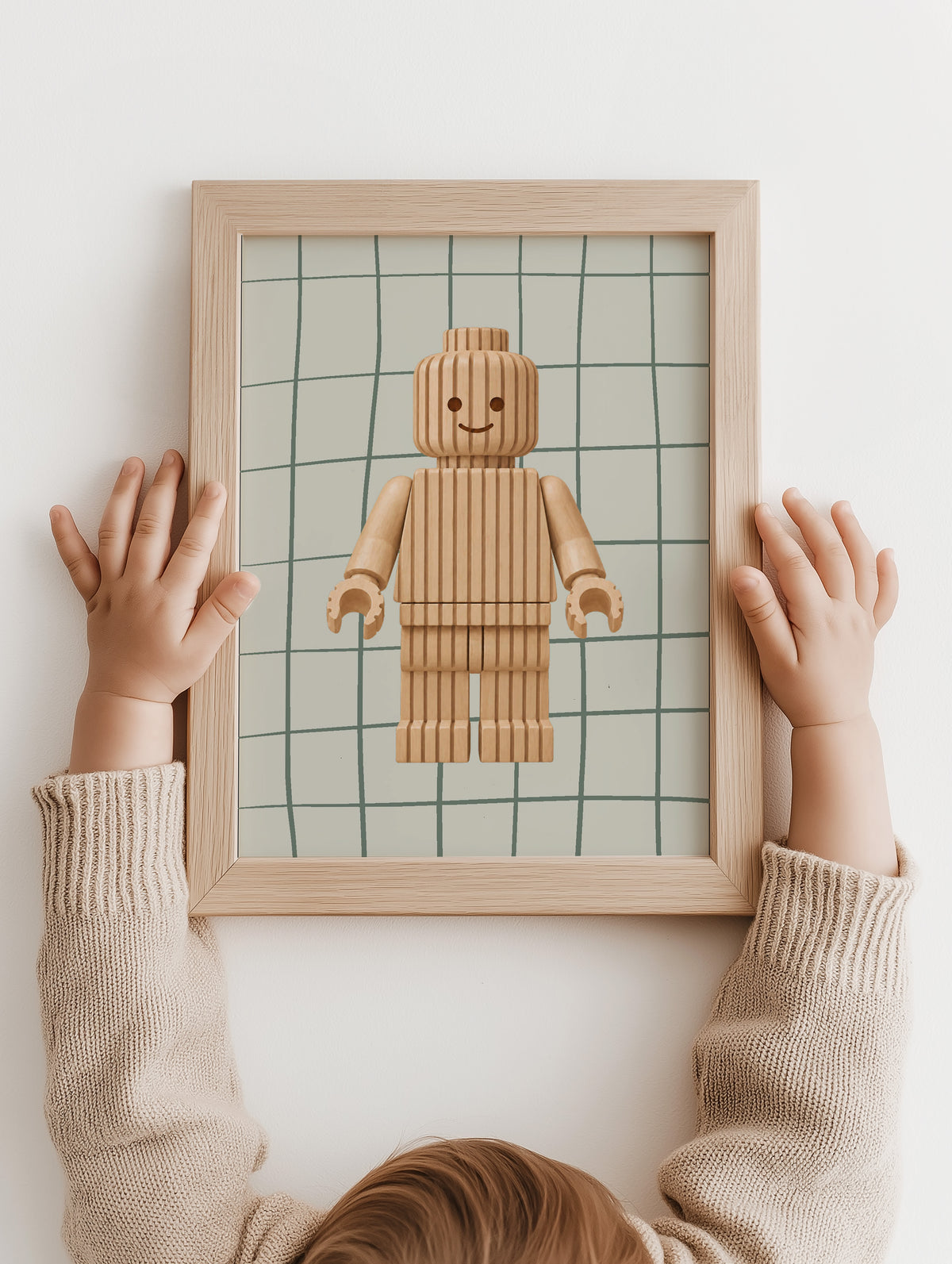 Kinderhanden houden de Block Buddy | cloudy sage poster in een houten lijst
