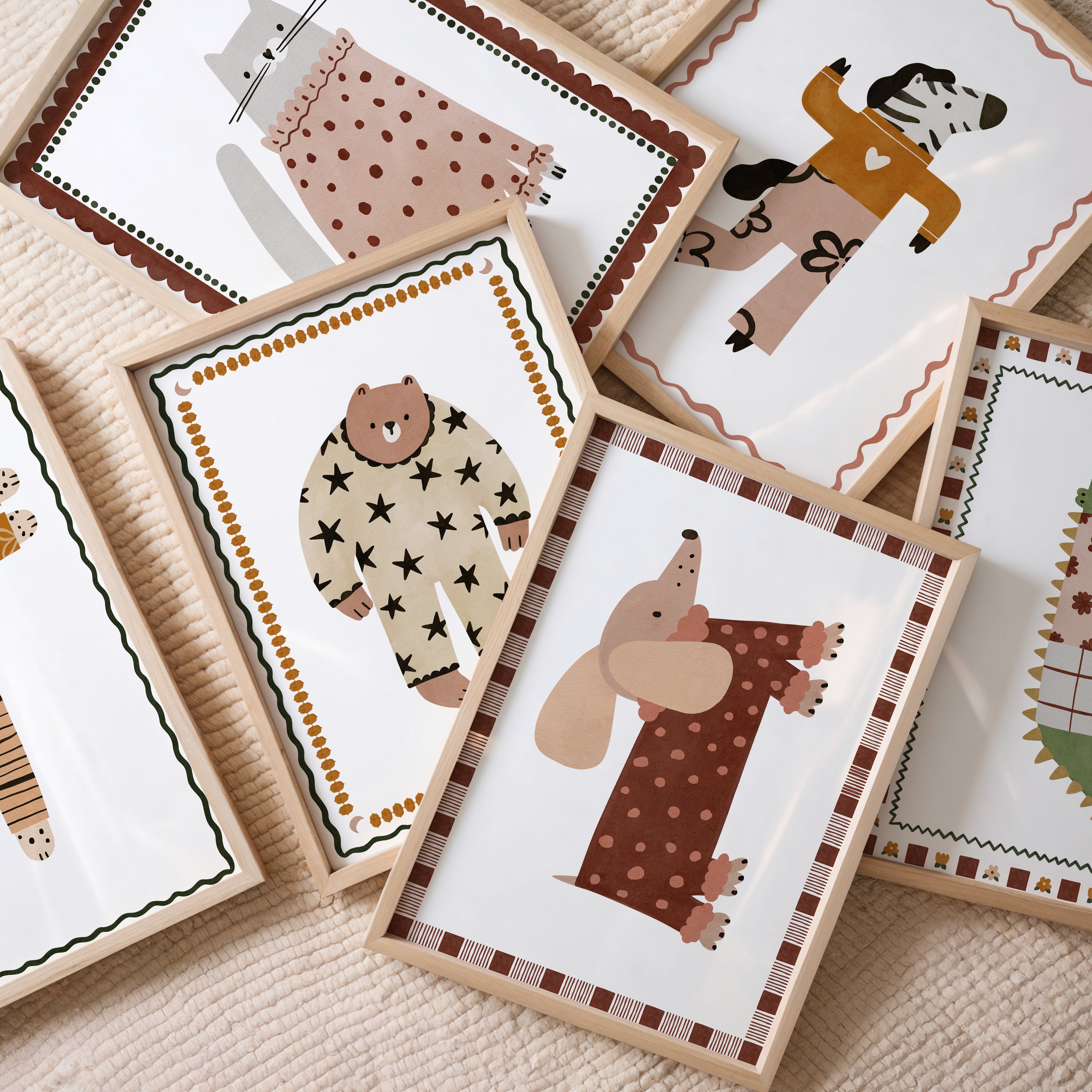 Retro kinderkamer posters met speelse dierenillustraties in warme aardetinten, ingelijst in lichte houten lijsten.