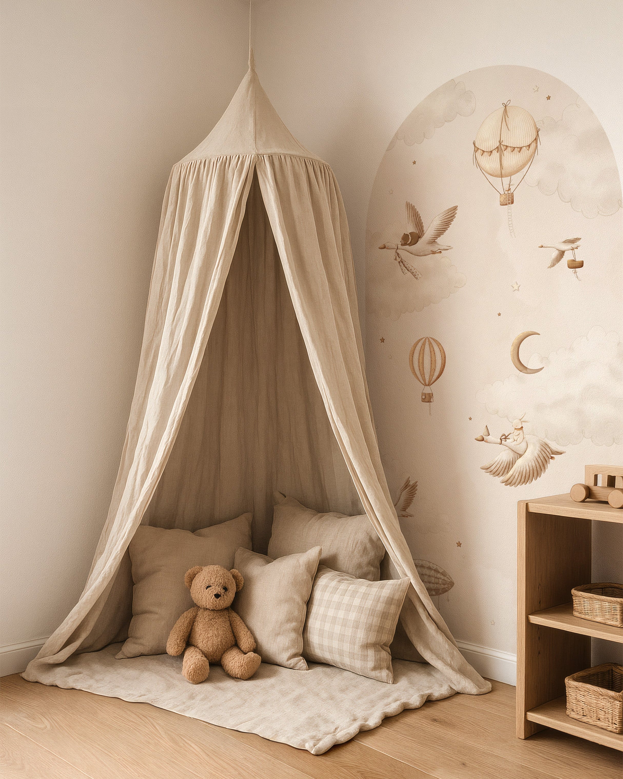 Ronde muursticker met luchtballonnen, vogels en maan in zachte beige tinten, gecombineerd met een knusse leeshoek in natuurlijke materialen.