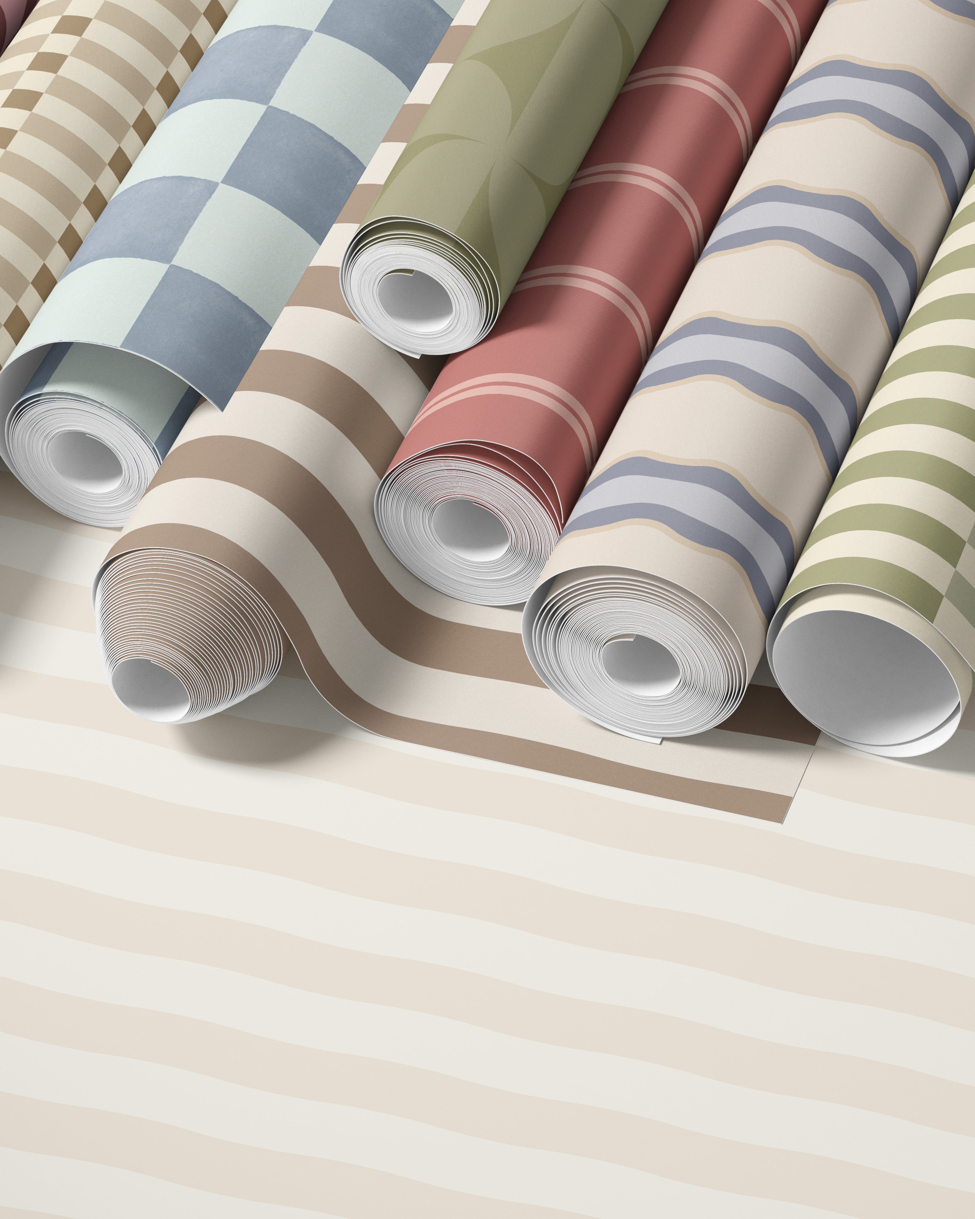 Opgerolde rollen kinderkamer behang met zachte strepen en patronen in rustige tinten zoals beige, groen, blauw en roze.