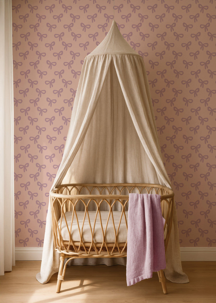Bows lila strikjesbehang in een babykamer met rotan ledikant