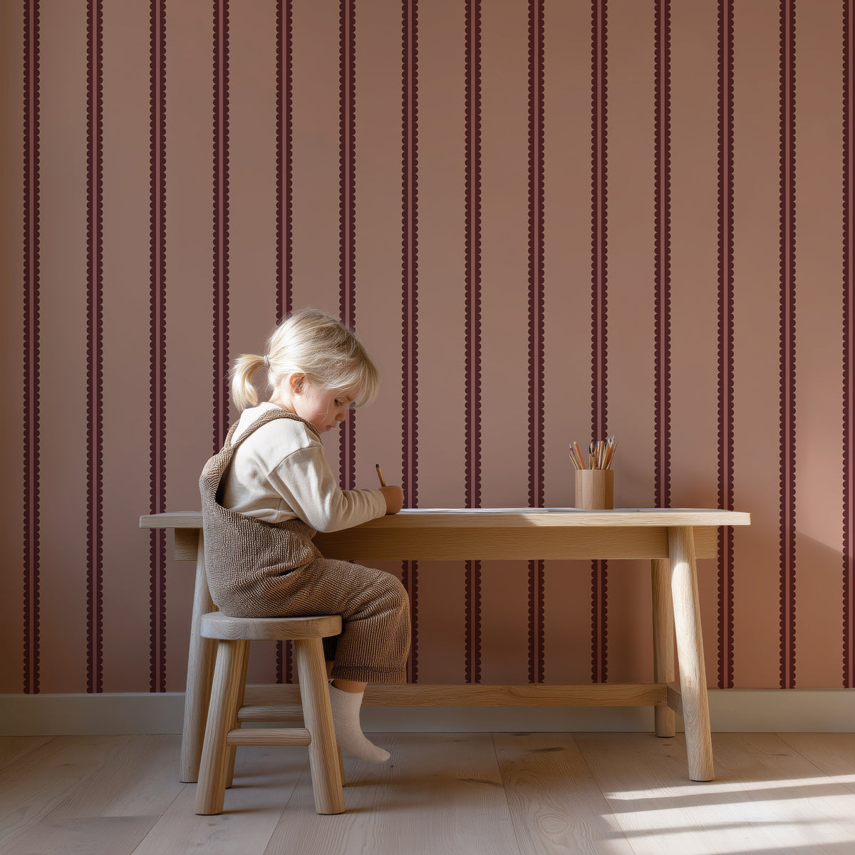 Scalloped Twins - blush rouge behang als achtergrond bij een kind aan een houten bureau