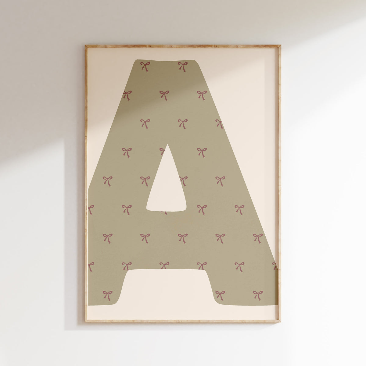 Gepersonaliseerde letterposter met strikjes in sagegroen in een kinderkamer